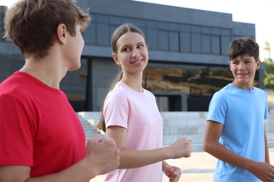 Photo of Group of teenagers jogging outdoors. Morning run