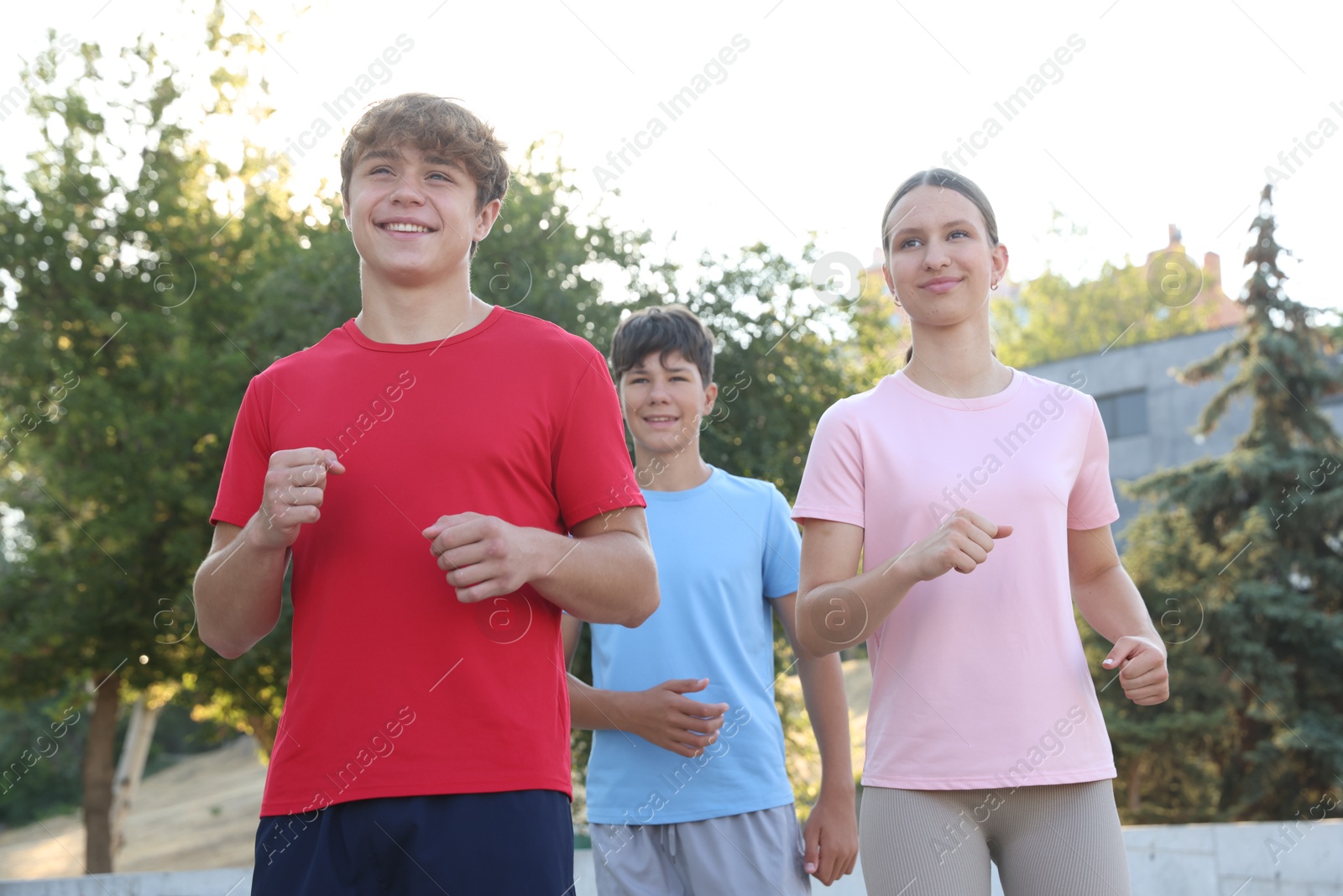 Group of teenagers running in park. Training outdoors Photo of Group of teenagers running in park. Training outdoors