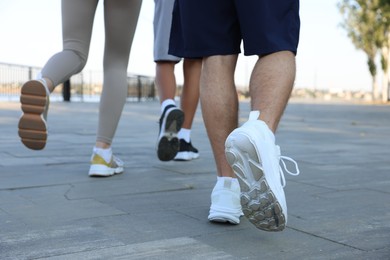 Photo of Group of teenagers jogging outdoors, closeup. Morning run