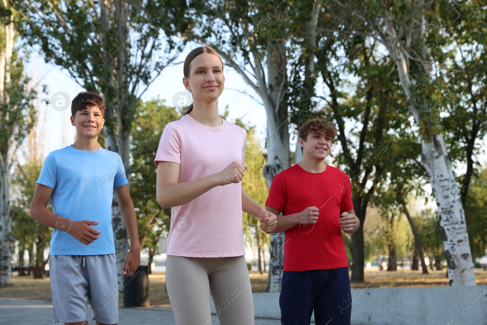 Group of teenagers running in park. Training outdoors Photo of Group of teenagers running in park. Training outdoors