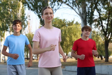 Photo of Group of teenagers running in park. Training outdoors