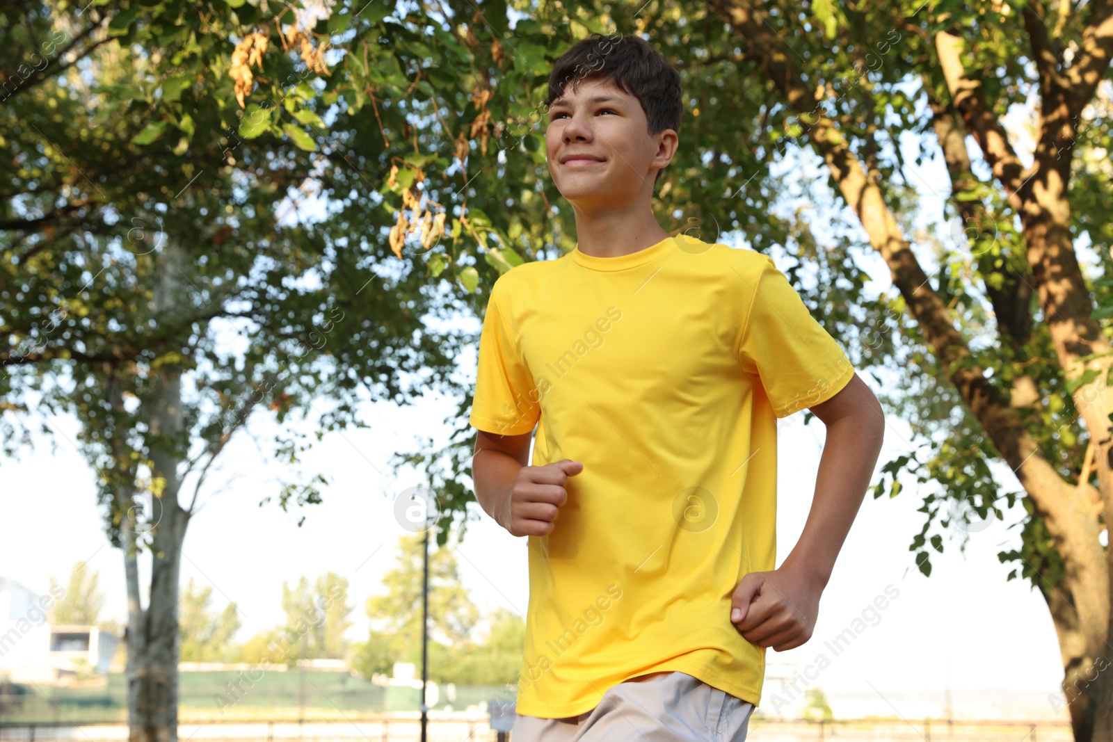Teenage boy running in park. Training outdoors Photo of Teenage boy running in park. Training outdoors