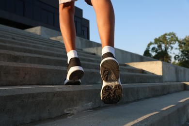 Photo of Teenage boy running up stairs outdoors, closeup