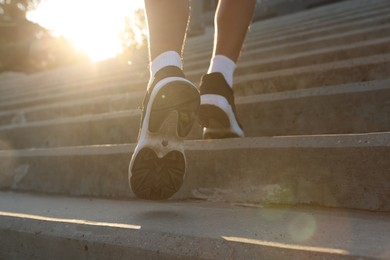 Photo of Teenage boy running up stairs outdoors, closeup