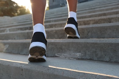 Photo of Teenage boy running up stairs outdoors, closeup