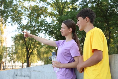 Photo of Teenage girl showing her friend something after training in park