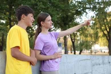Photo of Teenage girl showing her friend something after training in park