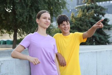 Photo of Teenage boy showing his friend something after training in park