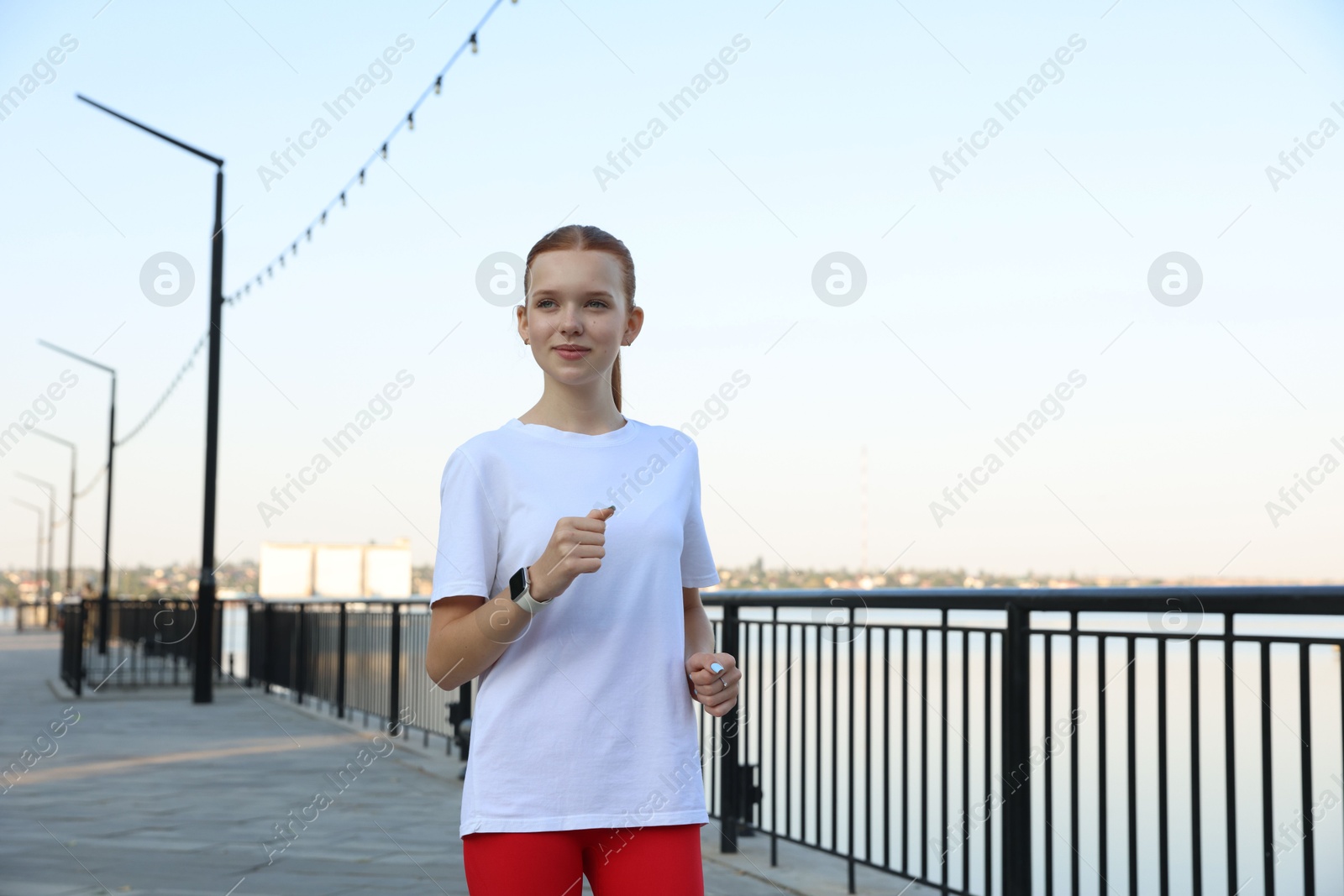 Beautiful teenage girl jogging outdoors. Morning run Photo of Beautiful teenage girl jogging outdoors. Morning run