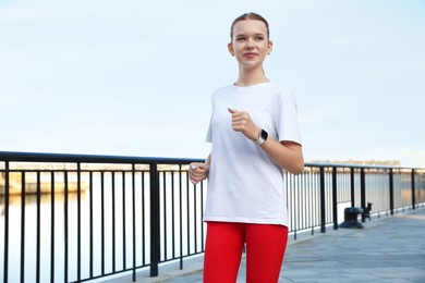 Photo of Beautiful teenage girl jogging outdoors. Morning run