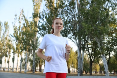 Photo of Teenage girl jogging in park. Morning run