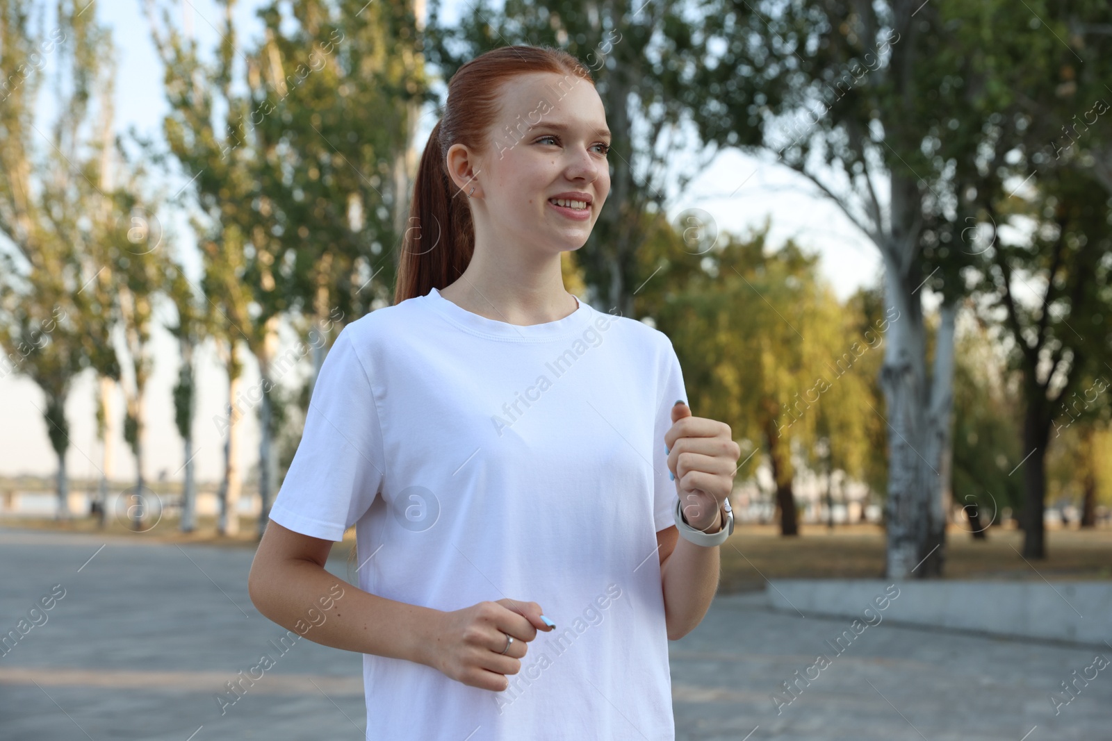 Teenage girl jogging in park. Morning run Photo of Teenage girl jogging in park. Morning run