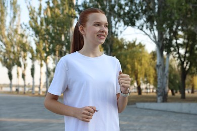 Photo of Teenage girl jogging in park. Morning run