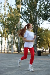 Photo of Teenage girl jogging in park. Morning run