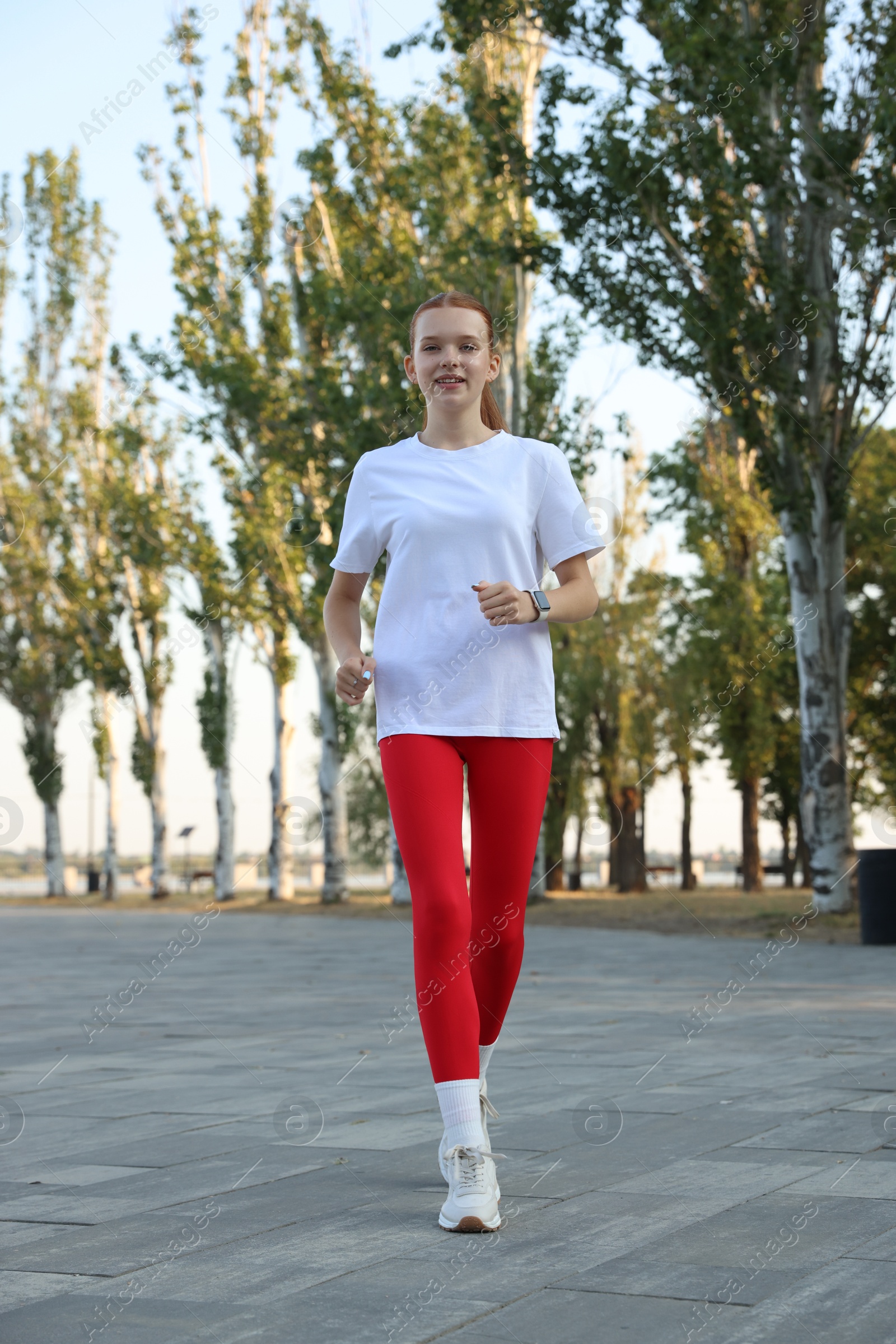 Teenage girl jogging in park. Morning run Photo of Teenage girl jogging in park. Morning run