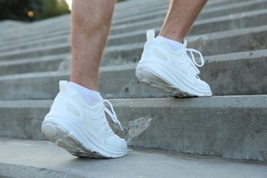 Photo of Teenage boy running up stairs outdoors, closeup