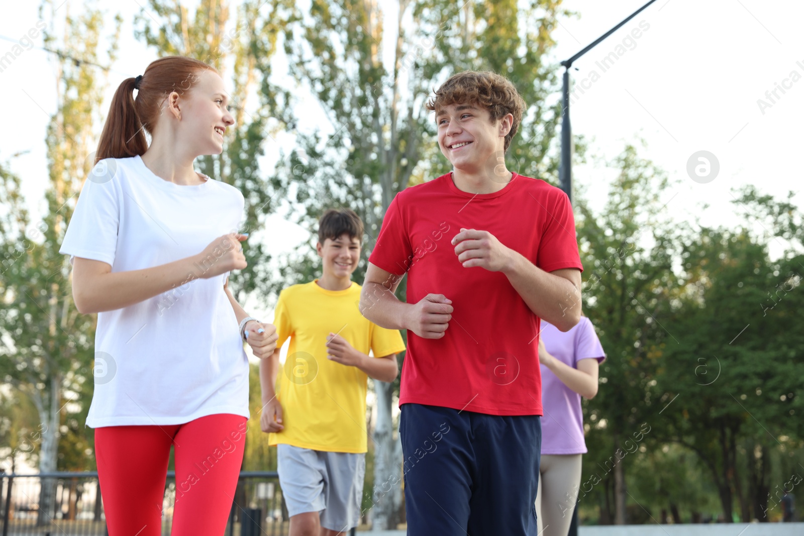 Group of teenagers jogging outdoors. Morning run Photo of Group of teenagers jogging outdoors. Morning run