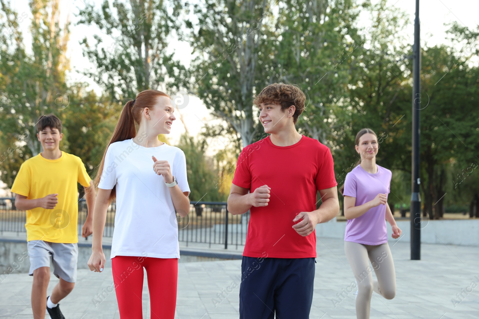 Group of teenagers jogging outdoors. Morning run Photo of Group of teenagers jogging outdoors. Morning run