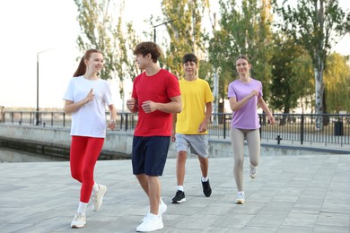 Photo of Group of teenagers jogging outdoors. Morning run