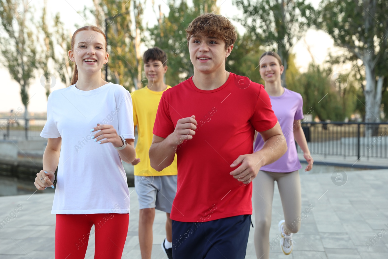 Group of teenagers jogging outdoors. Morning run Photo of Group of teenagers jogging outdoors. Morning run