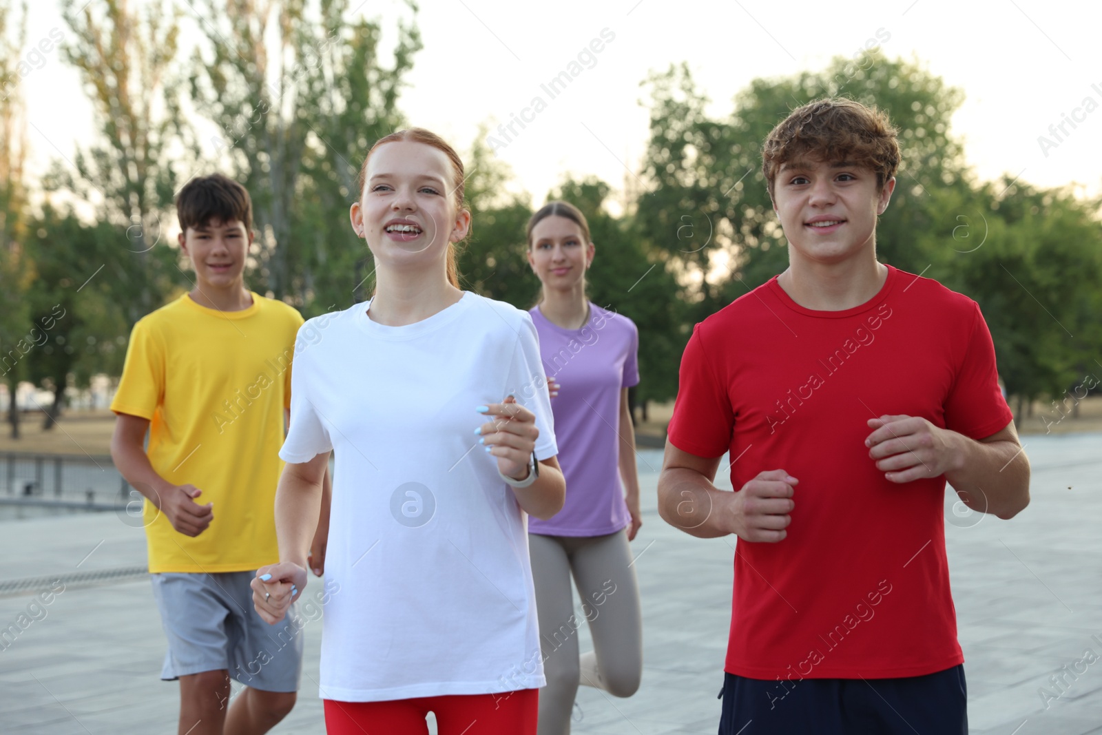 Group of teenagers jogging outdoors. Morning run Photo of Group of teenagers jogging outdoors. Morning run