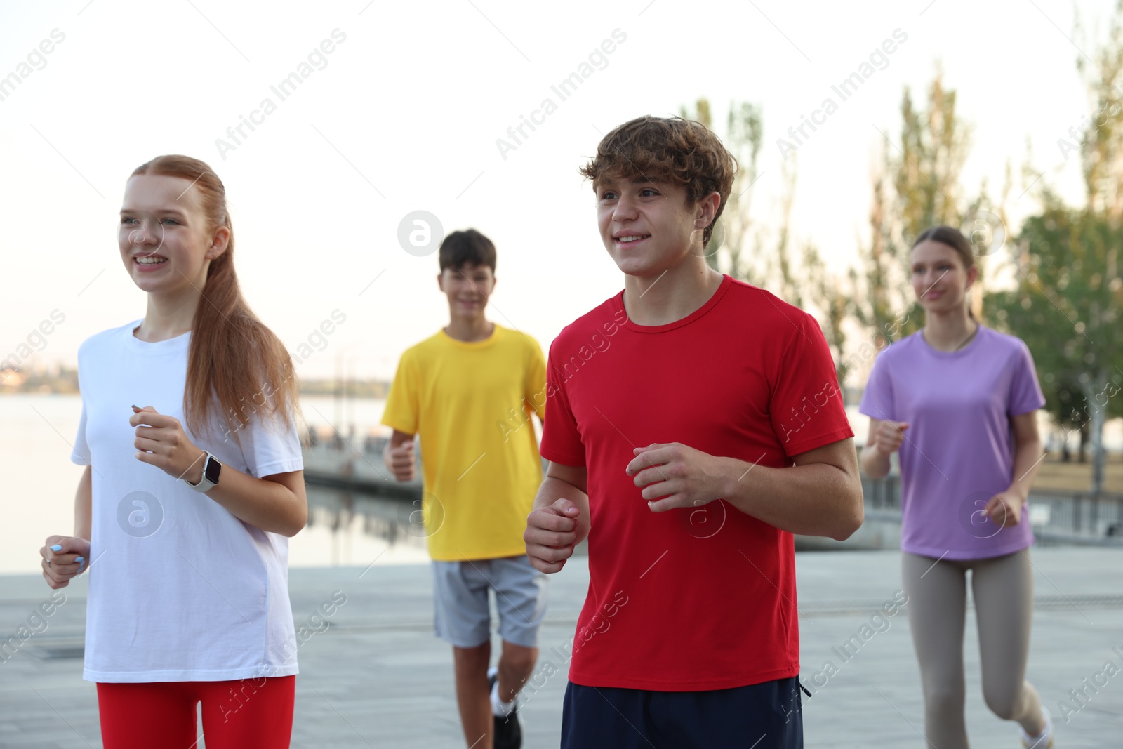 Group of teenagers jogging outdoors. Morning run Photo of Group of teenagers jogging outdoors. Morning run