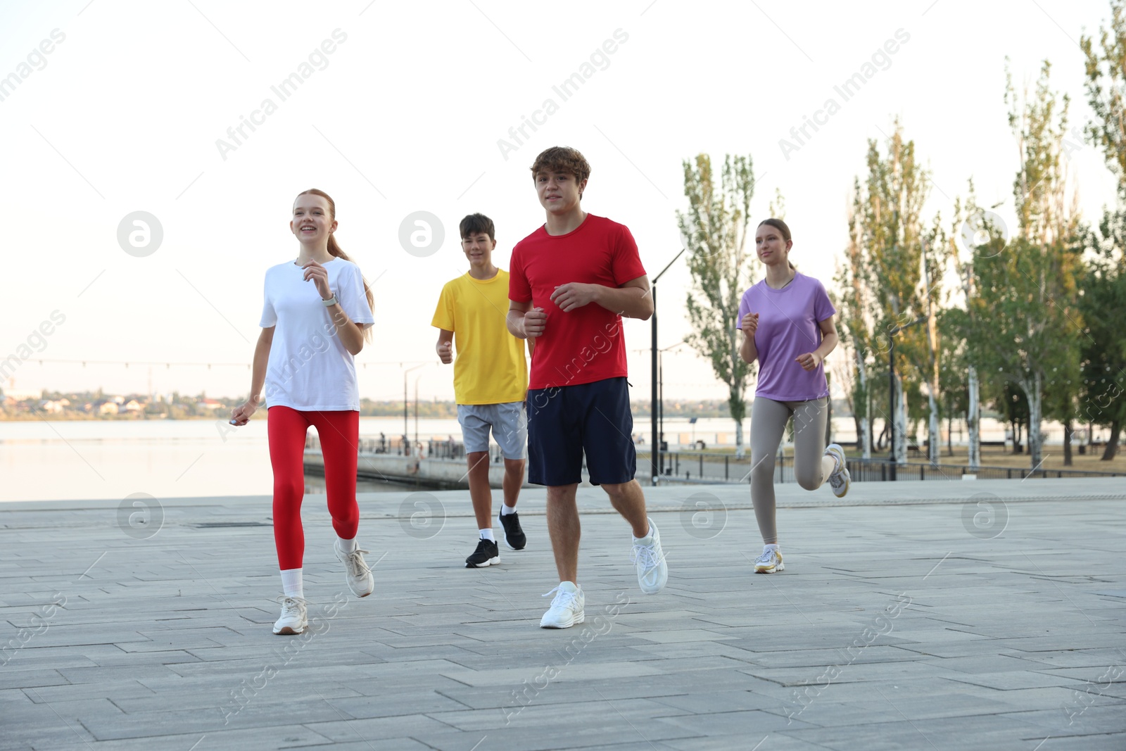 Group of teenagers jogging outdoors. Morning run Photo of Group of teenagers jogging outdoors. Morning run