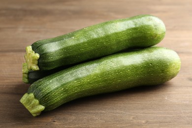 Photo of Fresh ripe zucchinis on wooden table, closeup