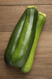 Photo of Fresh ripe zucchinis on wooden table, top view