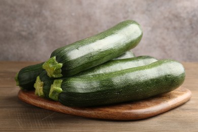 Photo of Fresh ripe zucchinis on wooden table, closeup