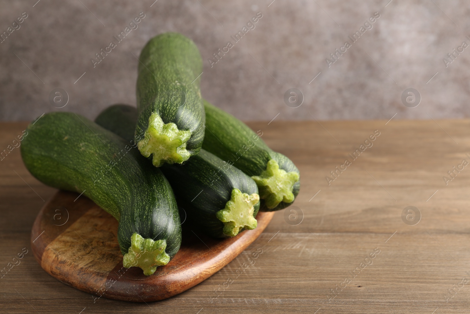 Fresh ripe zucchinis on wooden table, closeup. Space for text Photo of Fresh ripe zucchinis on wooden table, closeup. Space for text