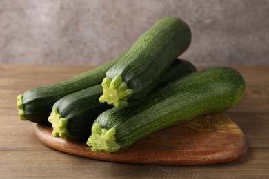 Photo of Fresh ripe zucchinis on wooden table, closeup
