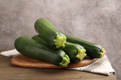 Photo of Fresh ripe zucchinis on wooden table, closeup
