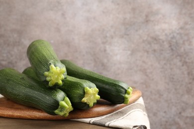 Photo of Fresh ripe zucchinis on wooden table, closeup. Space for text