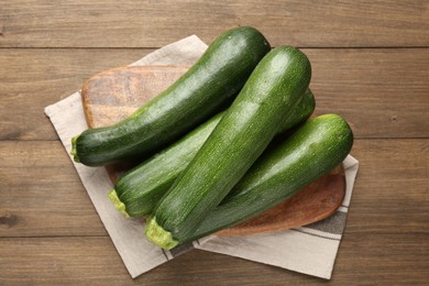 Photo of Fresh ripe zucchinis on wooden table, top view