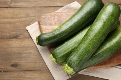Photo of Fresh ripe zucchinis on wooden table, top view. Space for text