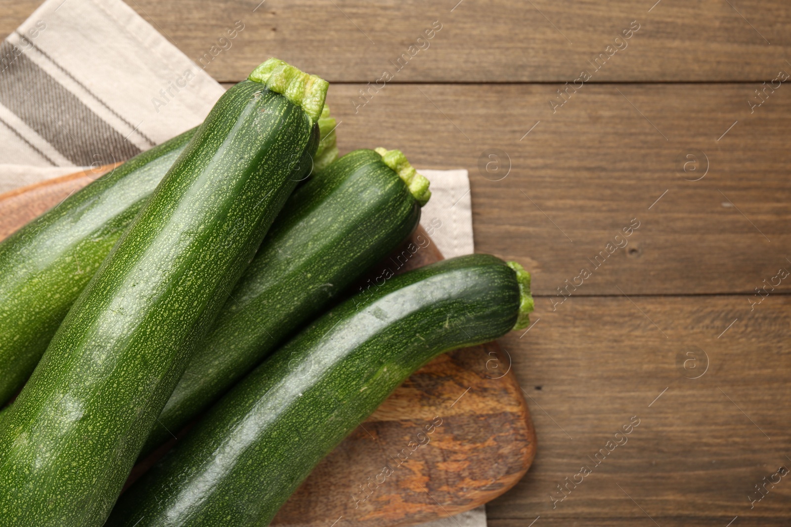 Fresh ripe zucchinis on wooden table, top view. Space for text Photo of Fresh ripe zucchinis on wooden table, top view. Space for text