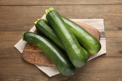 Photo of Fresh ripe zucchinis on wooden table, top view