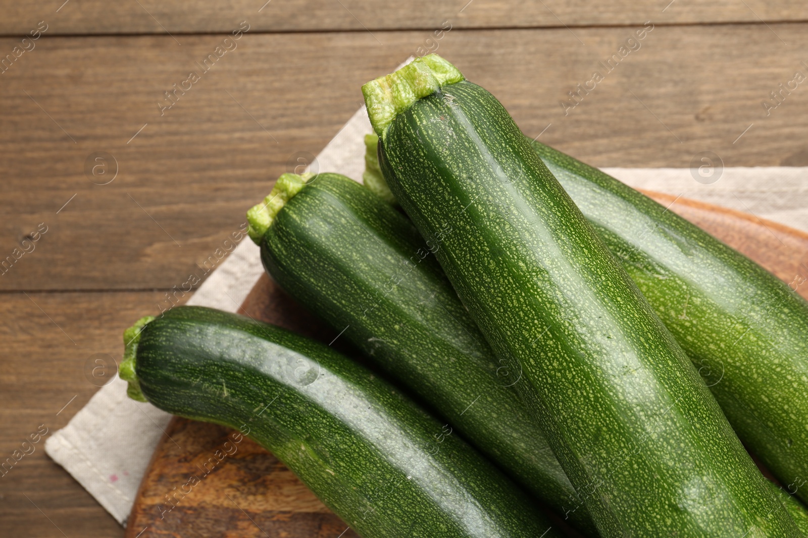 Fresh ripe zucchinis on wooden table, top view. Space for text Photo of Fresh ripe zucchinis on wooden table, top view. Space for text