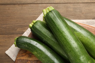 Photo of Fresh ripe zucchinis on wooden table, top view. Space for text