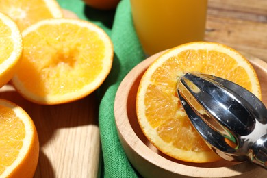 Photo of Making fresh juice. Juicer and oranges on table, closeup
