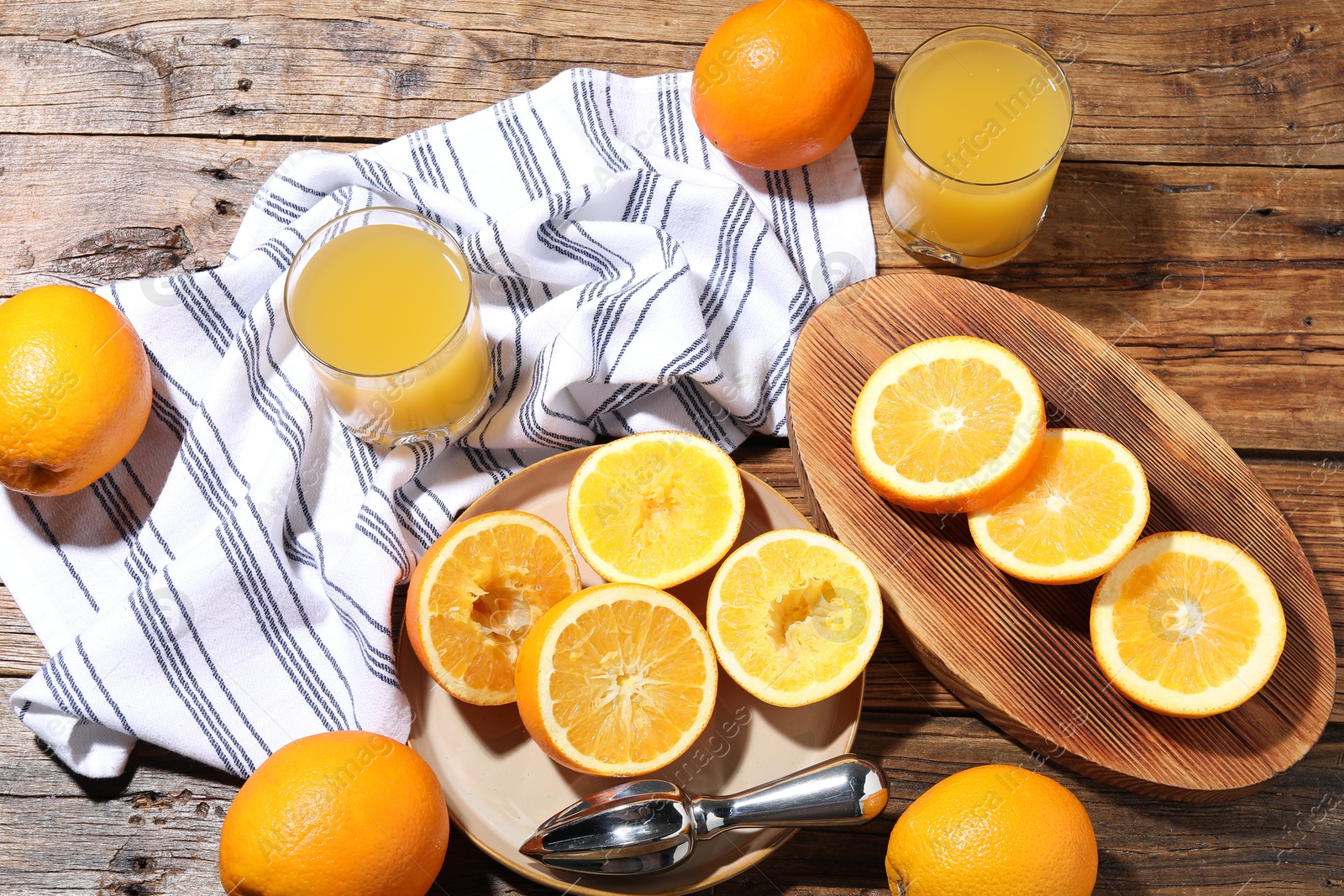 Freshly squeezed orange juice, fruits and juicer on wooden table, flat lay Photo of Freshly squeezed orange juice, fruits and juicer on wooden table, flat lay