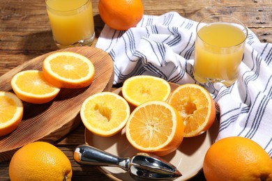 Photo of Freshly squeezed orange juice, fruits and juicer on wooden table, closeup