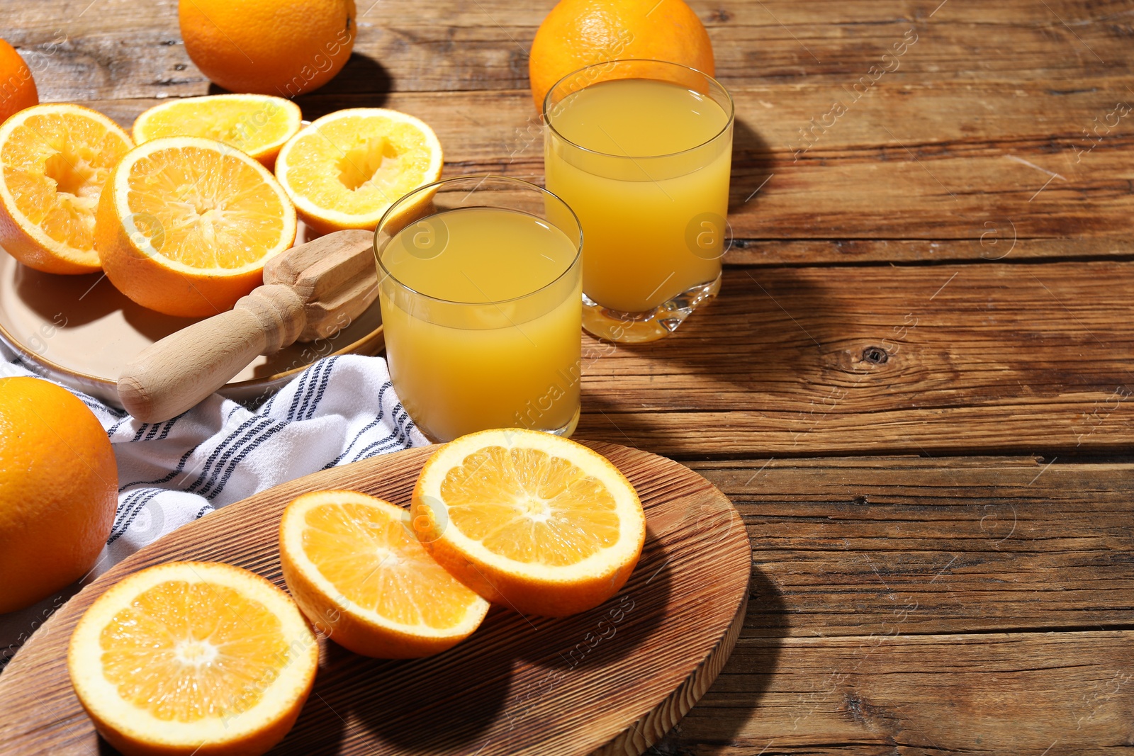 Freshly squeezed orange juice, fruits and juicer on wooden table, closeup. Space for text Photo of Freshly squeezed orange juice, fruits and juicer on wooden table, closeup. Space for text