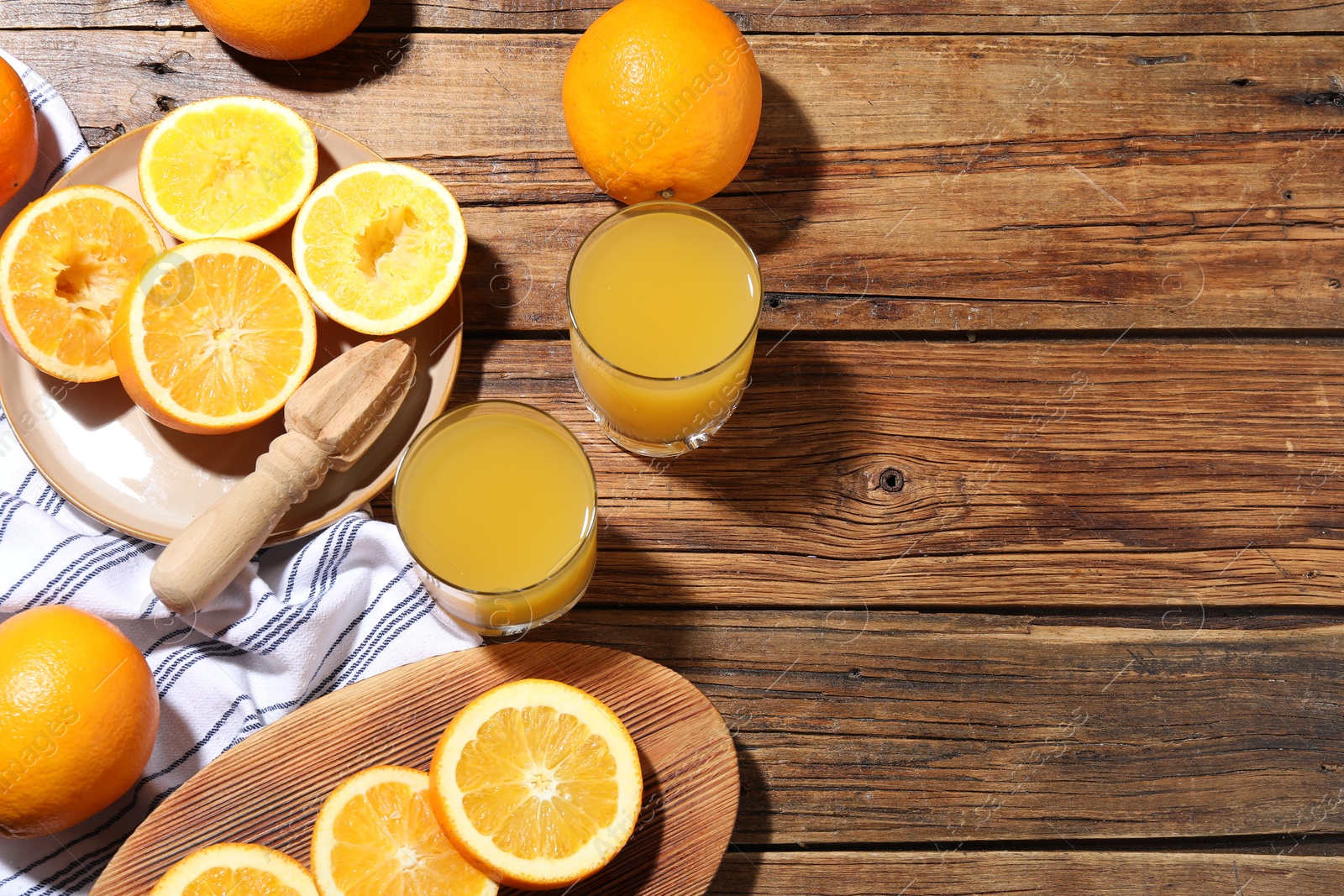 Freshly squeezed orange juice, fruits and juicer on wooden table, flat lay. Space for text Photo of Freshly squeezed orange juice, fruits and juicer on wooden table, flat lay. Space for text