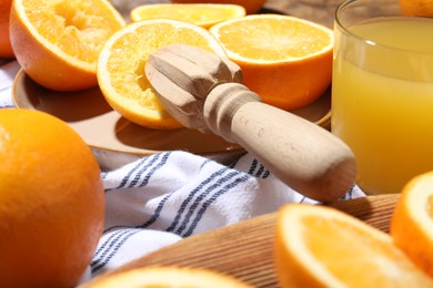 Photo of Freshly squeezed orange juice, fruits and juicer on table, closeup