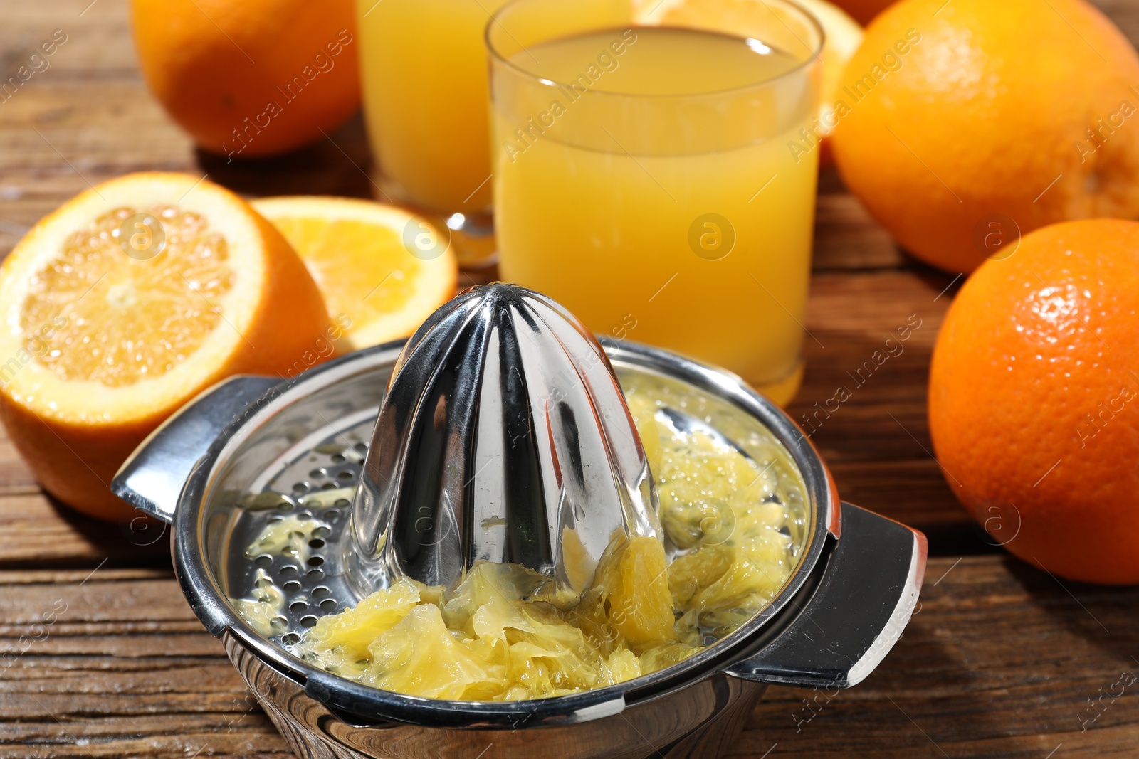 Freshly squeezed orange juice, fruits and juicer on wooden table, closeup Photo of Freshly squeezed orange juice, fruits and juicer on wooden table, closeup