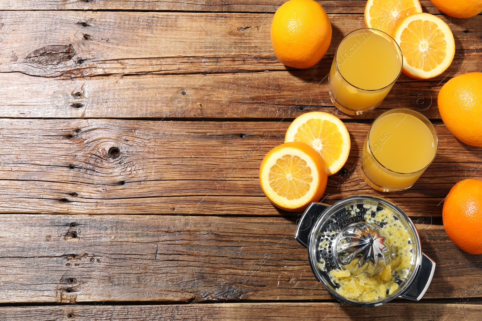 Freshly squeezed orange juice, fruits and juicer on wooden table, flat lay. Space for text Photo of Freshly squeezed orange juice, fruits and juicer on wooden table, flat lay. Space for text