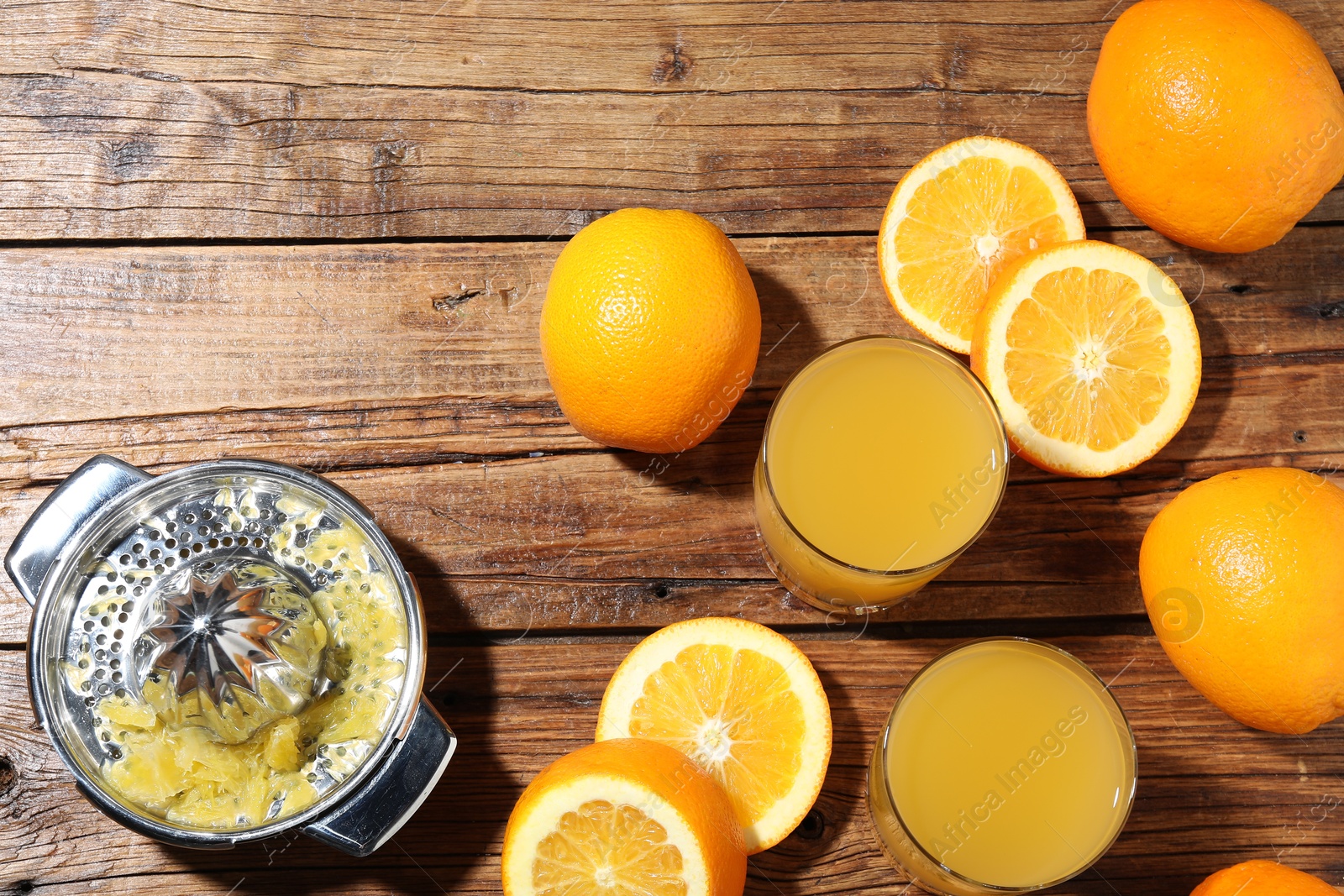 Freshly squeezed orange juice, fruits and juicer on wooden table, flat lay. Space for text Photo of Freshly squeezed orange juice, fruits and juicer on wooden table, flat lay. Space for text