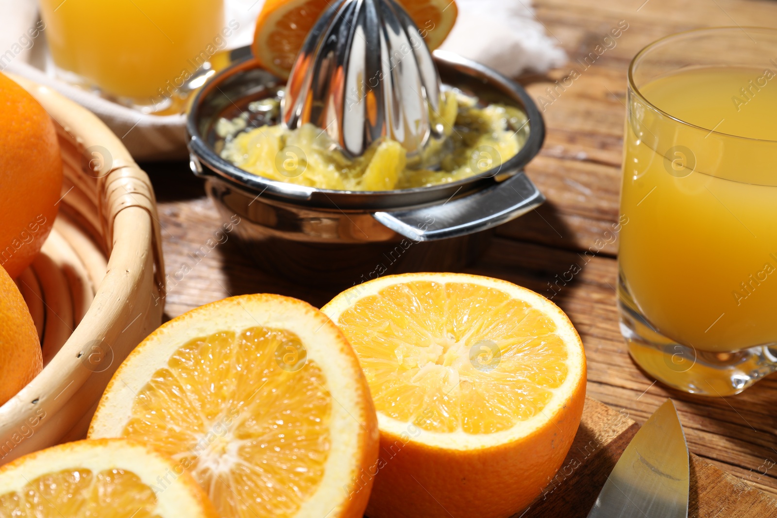 Freshly squeezed orange juice, fruits and juicer on wooden table, closeup Photo of Freshly squeezed orange juice, fruits and juicer on wooden table, closeup